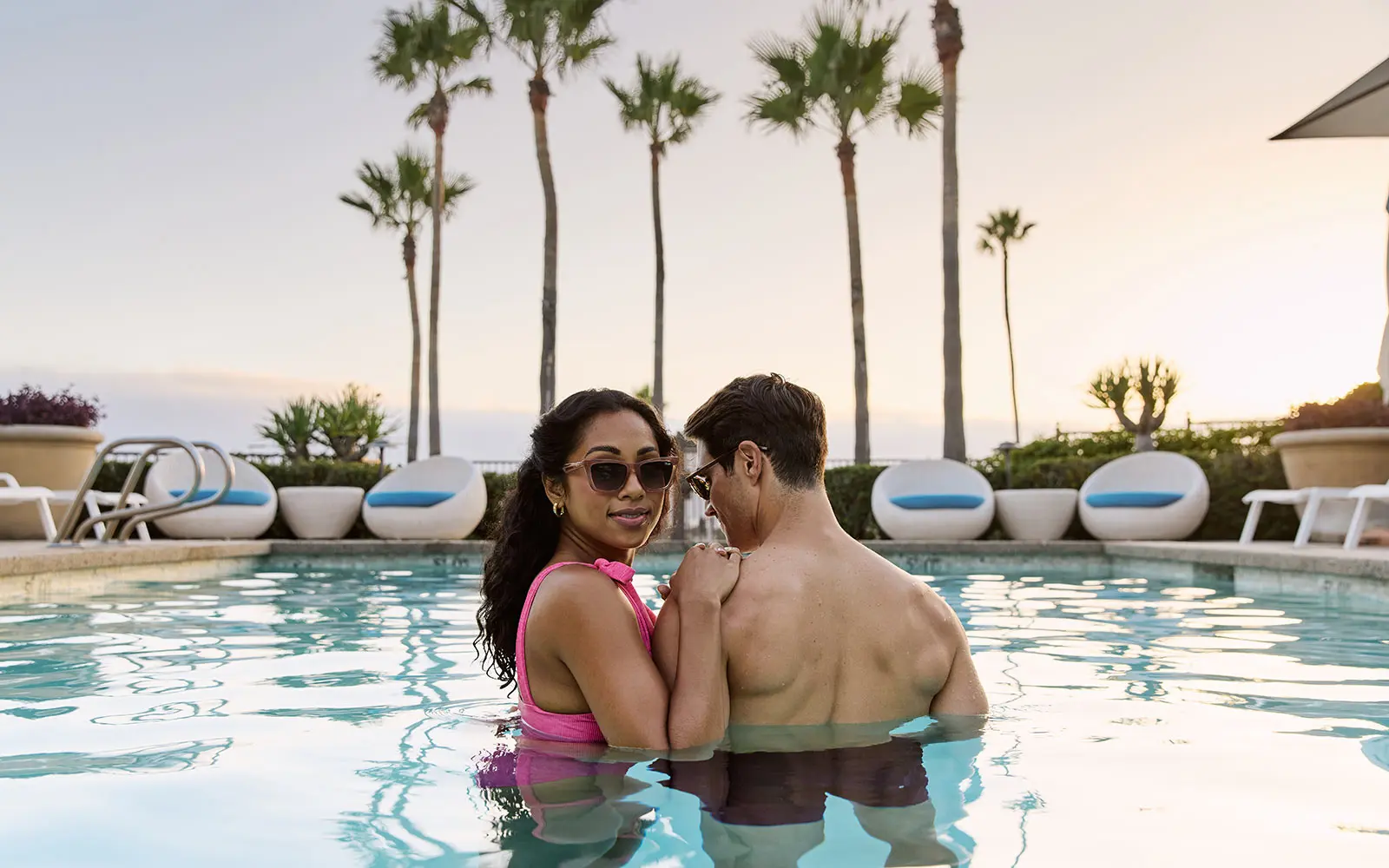 Couple in plunge pool at sunset