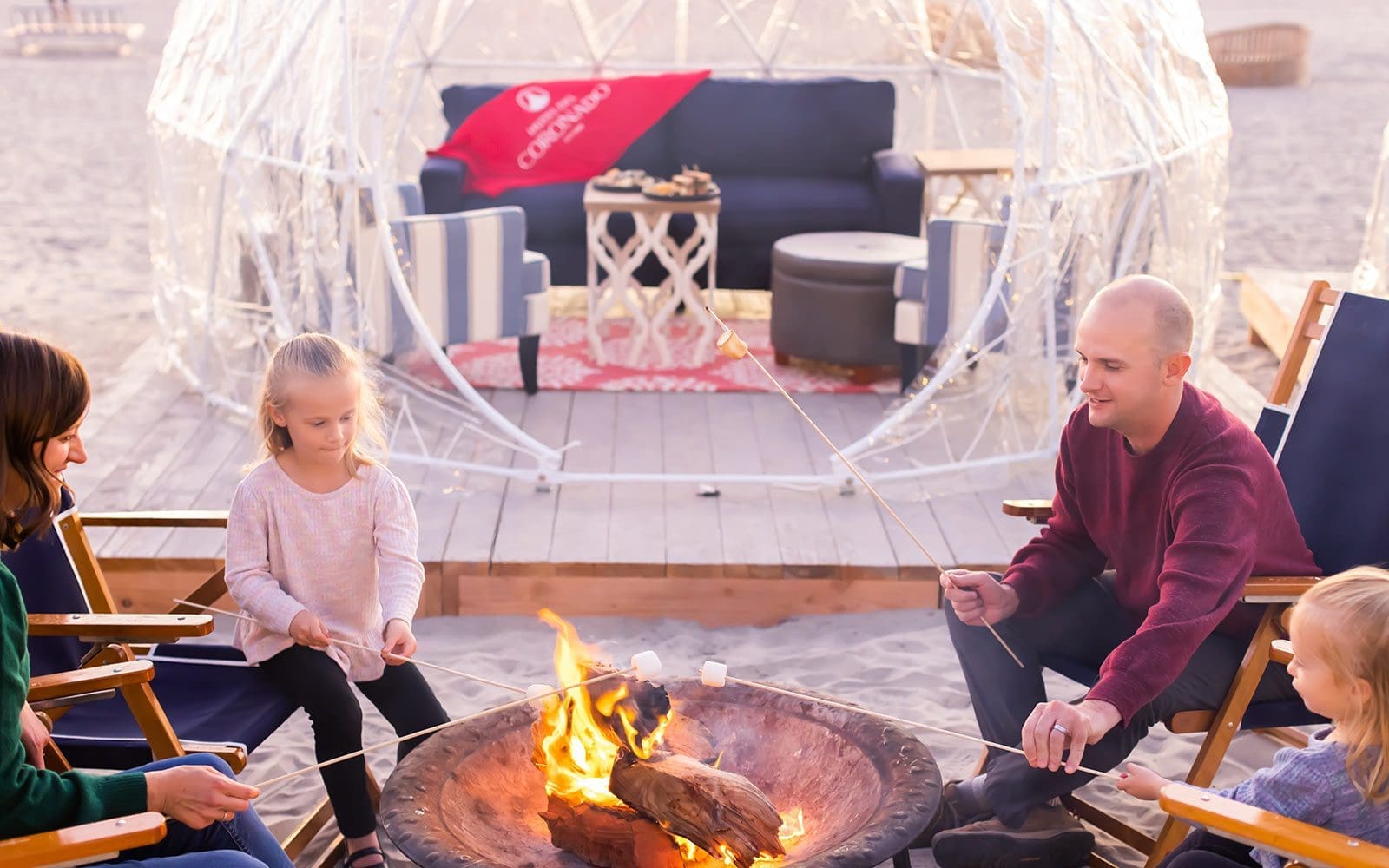 Family at beach bonfire and igloo