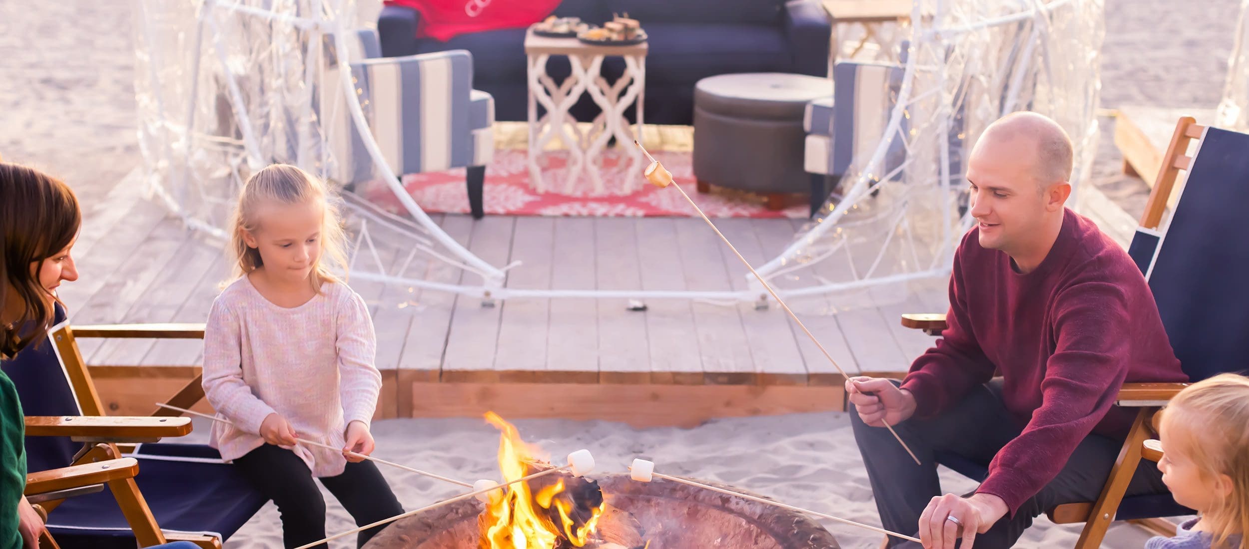 Family at beach bonfire and igloo