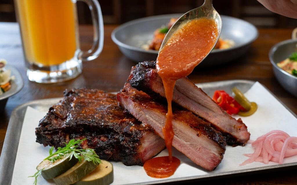BBQ sauce pouring on ribs