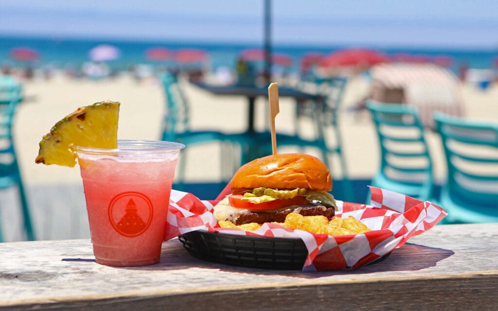 Burger and drink with tables and ocean view