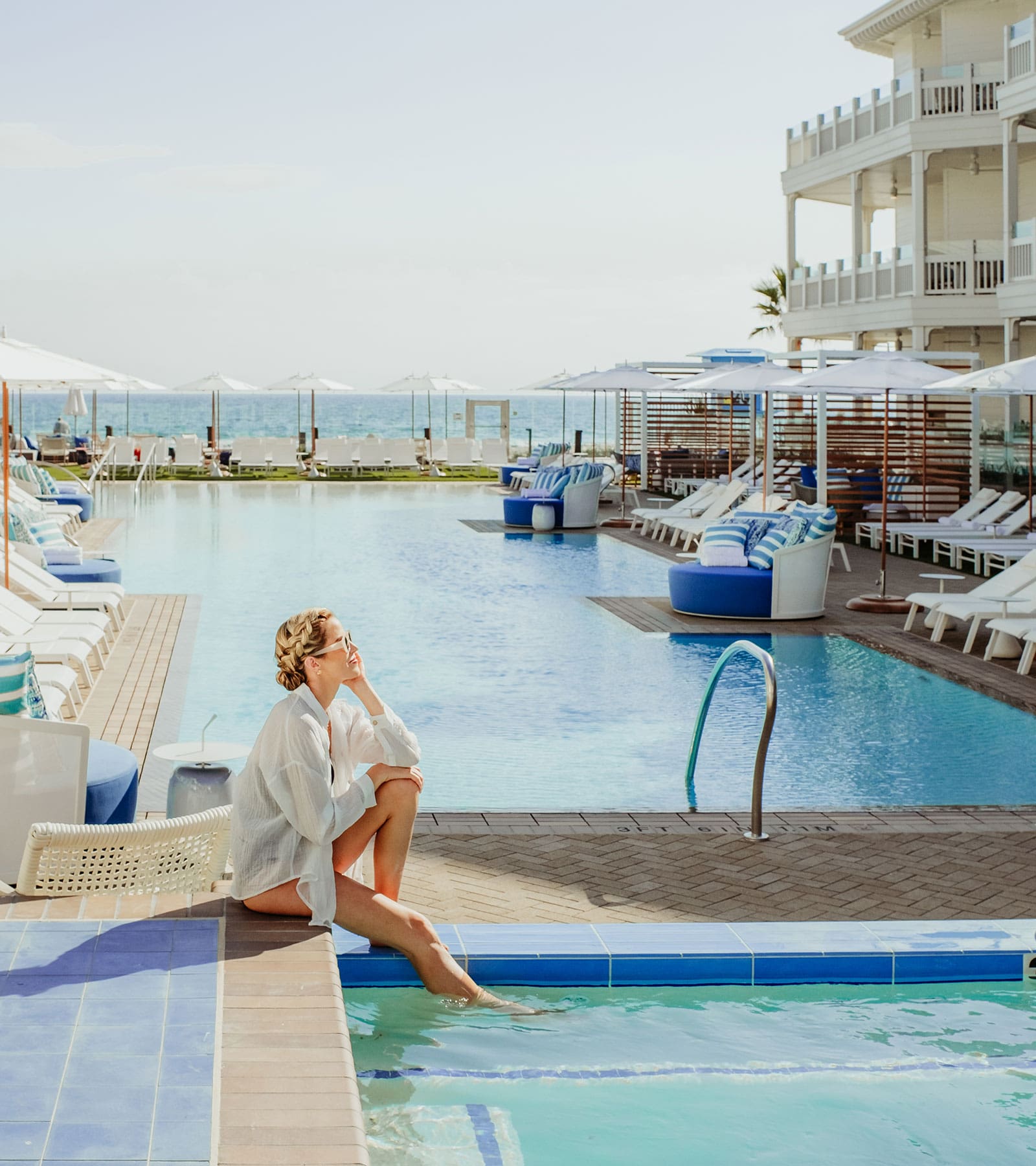 Woman sitting by jacuzzi and pool